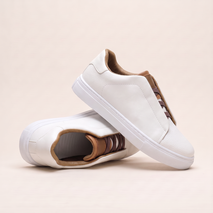Off white slip-on low-top sneakers angled to show the brown elastic panel and tan lining