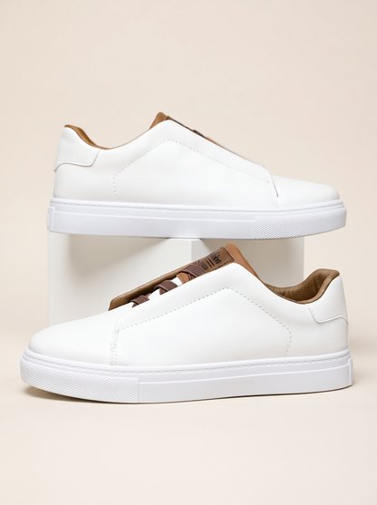 Pair of white slip-on low-top sneakers with tan lining and white cupsole, side profile